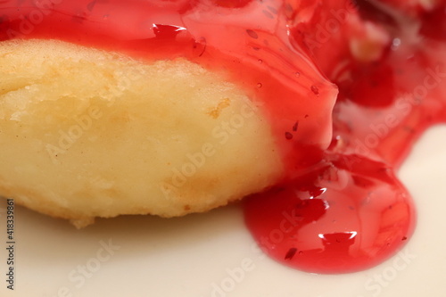 Delicious muffin with marmalade background. Sweet fritter with red jam texture. photo