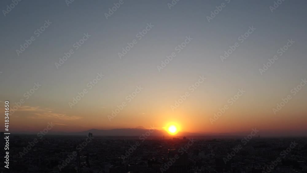TOKYO, JAPAN : Aerial high angle sunset CITYSCAPE of TOKYO and MOUNT FUJI. View of sinking sun and buildings. Japanese urban city life and metropolis concept. Time lapse tracking shot dusk to night. TOKYO, JAPAN : Aerial high angle sunset CITYSCAPE of TOKYO and MOUNT FUJI. View of sinking sun and buildings. Japanese urban city life and metropolis concept. Time lapse tracking shot dusk to night.