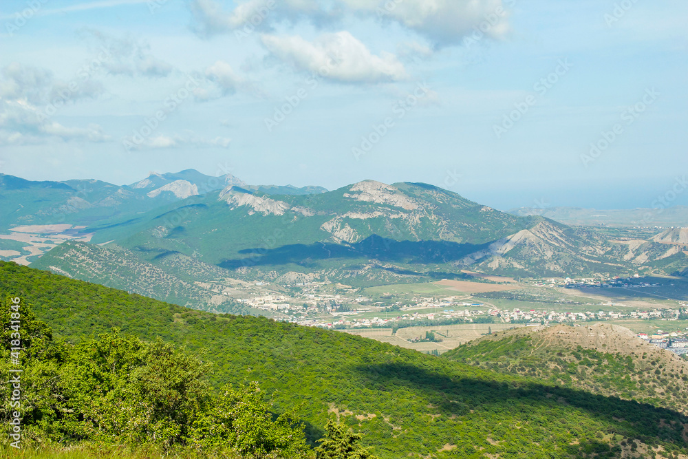Panorama of the Crimean mountains overlooking the city of Sudak on a sunny day.