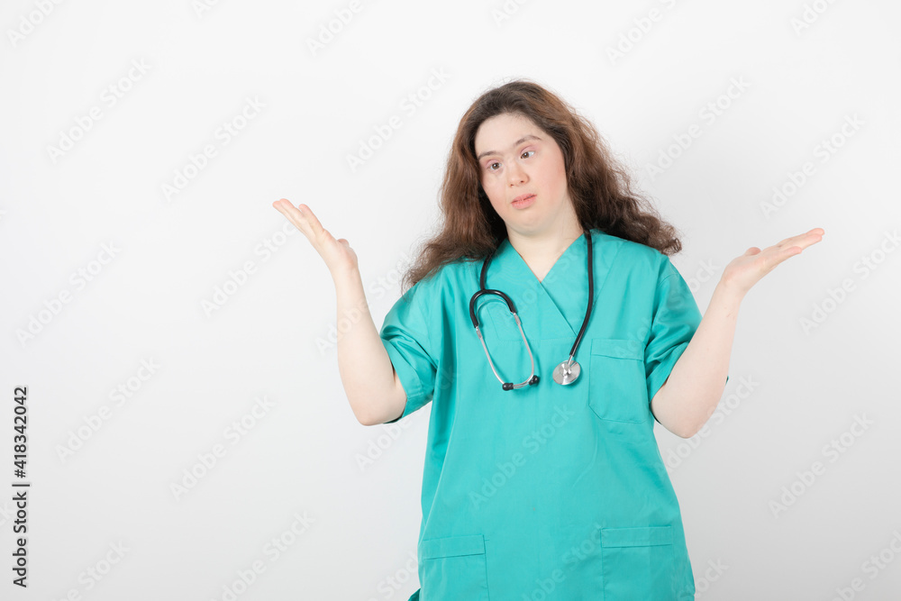 Young female doctor with down syndrome standing on white background Young female doctor with down syndrome standing on white background