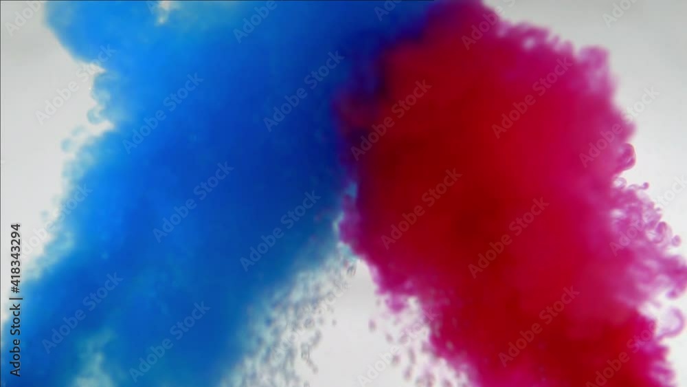 Mixing blue and red paint colors in water. Colored smoke effect