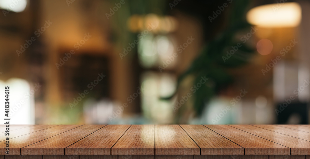 Empty wooden table top with lights bokeh on blur restaurant background.