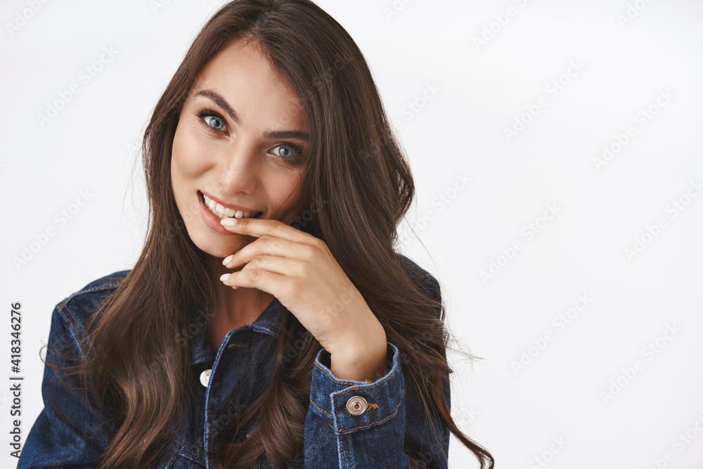 Beauty, women concept. Coquettish woman flirting with person, looking daring and silly biting finger, smiling joyfully, express sensuality and passion, standing white background