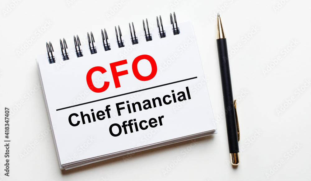 On a light background, a white notebook with are words CFO Chief Financial Officer and a pen. On a light background, a white notebook with are words CFO Chief Financial Officer and a pen.