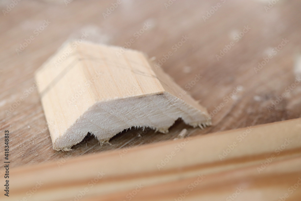 A sawn-off piece of wood lies on the floor. Wood works background. - obrazy, fototapety, plakaty 
