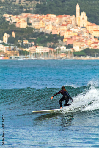 Photography surfer rides the ligurian wave during a winter day