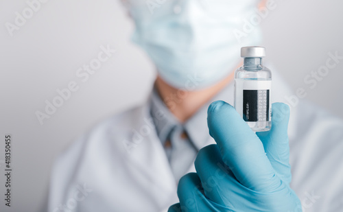 Doctors wear a surgical mask and glasses, Scientists, Scientists hold syringes and vaccines for COVID-19., vaccination and laboratory experiments. Virus protection concept COVID-19,