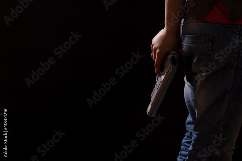 Juvenile delinquency. Child hiding gun. Criminal area.