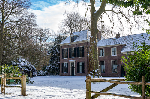 One of the old buildings in De Horsten park in Wassenaar, covered with a layer of snow photo