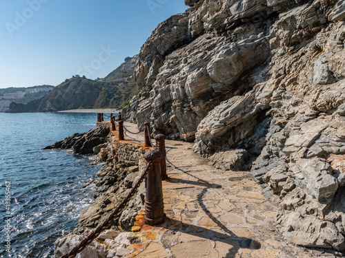 weathered Iron Poles with metal chains at the Cotobro beach near Almuñécar, Granada, Spain