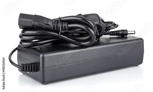 Power supply in black case with EU plug on cord isolated on white background photo