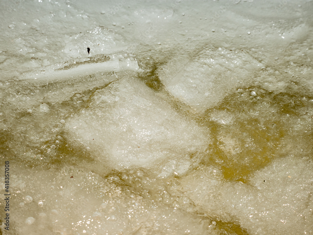 Melting piece of ice fallen into water. Structure of natural ice Melting piece of ice fallen into water. Structure of natural ice