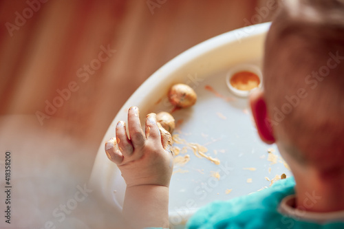 Wallpaper Mural Child's hands paints Easter quail eggs. Happy Easter card. The child develops fine motor skills with bright paints and quail eggs. Copy space for text  Torontodigital.ca