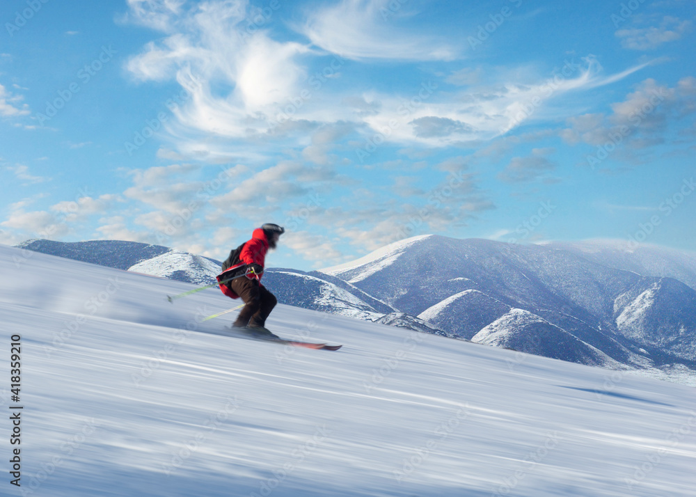 Man in red jacket skiing down slope in bright sunshine