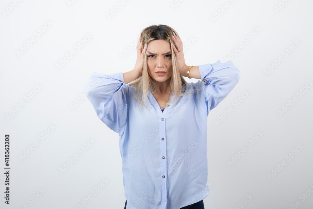 Image of blonde beautiful woman holding her head on white background Image of blonde beautiful woman holding her head on white background