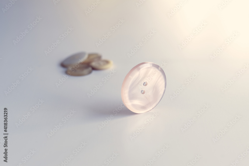 Round sewing button with two holes isolated on the white background with pastel colors Round sewing button with two holes isolated on the white background with pastel colors