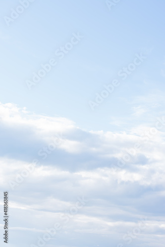 Natural background with light blue spindrift clouds. Abstract vertical backdrop