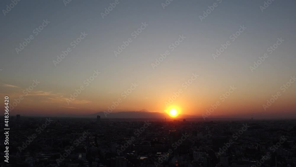 TOKYO, JAPAN : Aerial high angle sunset CITYSCAPE of TOKYO and MOUNT FUJI. View of sinking sun and buildings. Japanese urban city life and metropolis concept. Time lapse zoom out shot dusk to night. TOKYO, JAPAN : Aerial high angle sunset CITYSCAPE of TOKYO and MOUNT FUJI. View of sinking sun and buildings. Japanese urban city life and metropolis concept. Time lapse zoom out shot dusk to night.