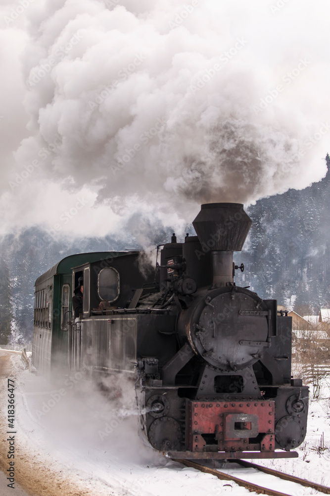 Old train with big smoke during winter time in Moldovita, Bucovina. Romaniia.