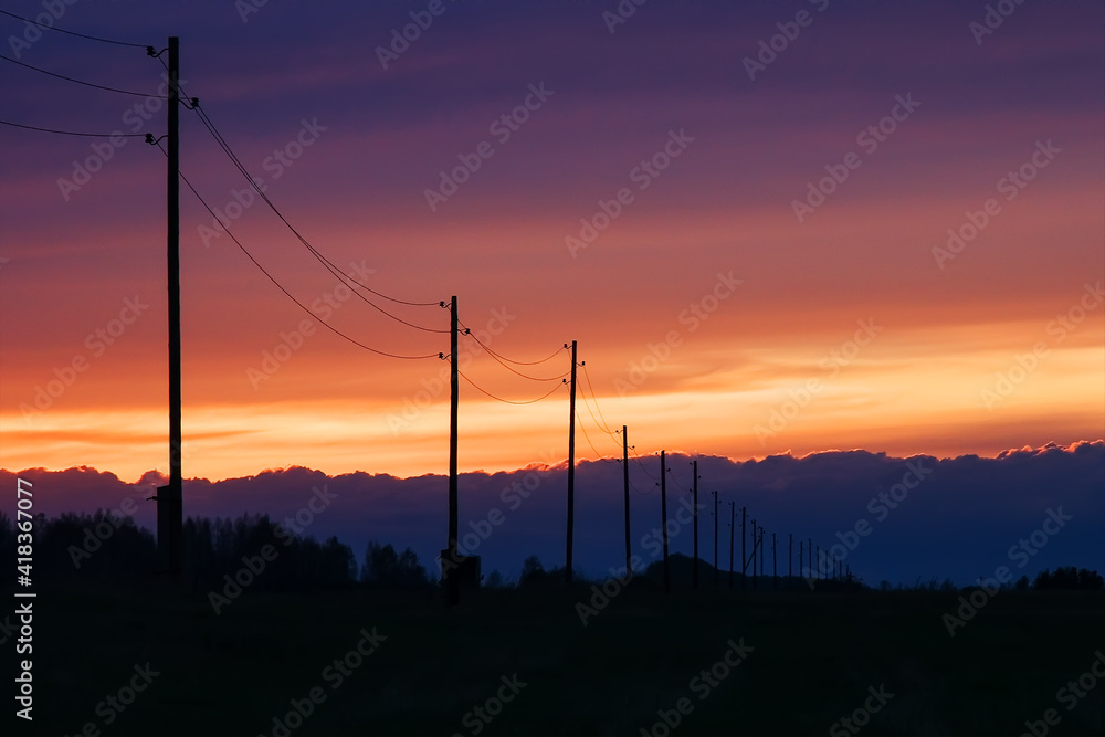 telegraph poles against the background of a multicolored colorful sunset sky