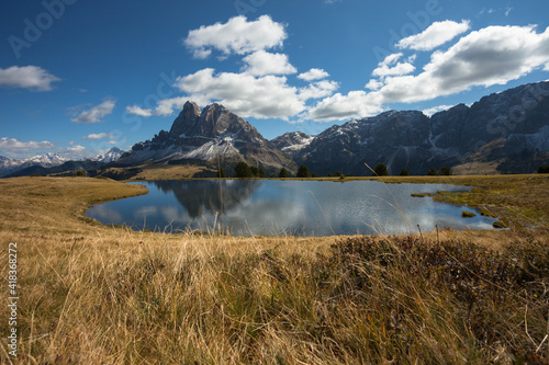 Sass de Putia reflects itself over a small alpine lake in Dolomites at evening photo