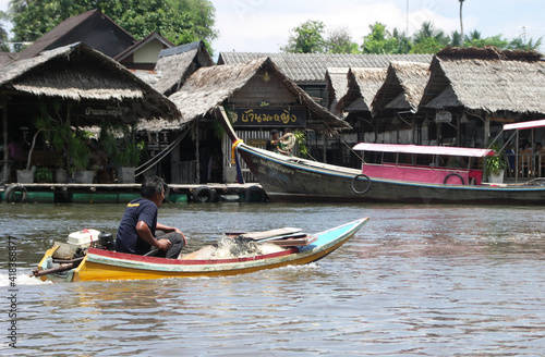 Local fisherman riding is one place longtail boat along the river. photo