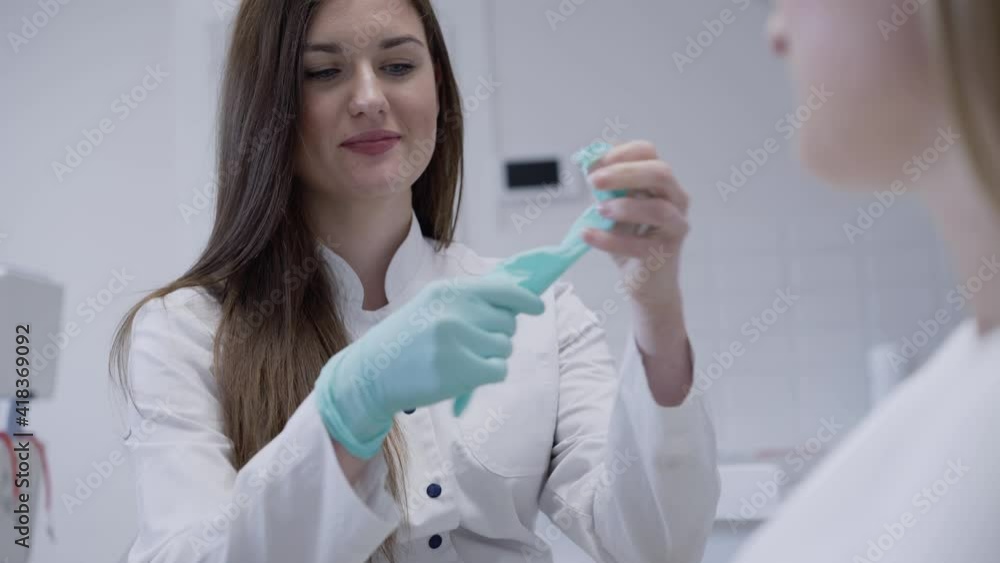 Dentist having consultation about toothache with patient and wearing gloves Dentist having consultation about toothache with patient and wearing gloves