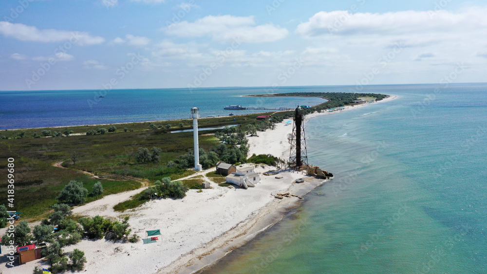 Aerial drone top down photo of seascape of island with sandy beach, turquoise clear waters of black sea in Ukraine, trees and two lighthouses. island Dzharilgach