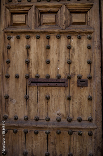 Old rustic vintage wood door closeup background. Ornamental gate detail texture pattern traditional ancient spanish design.