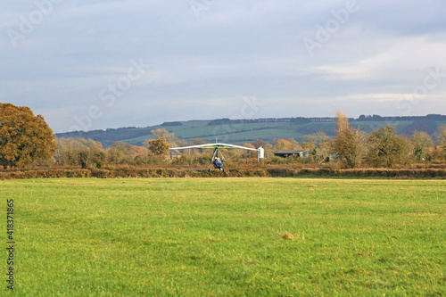 Canvas-taulu Ultralight airplane landing on a grass strip