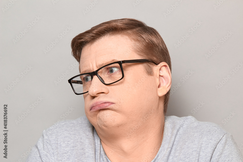 Portrait of tired disappointed man puffing cheeks Portrait of tired disappointed man puffing cheeks