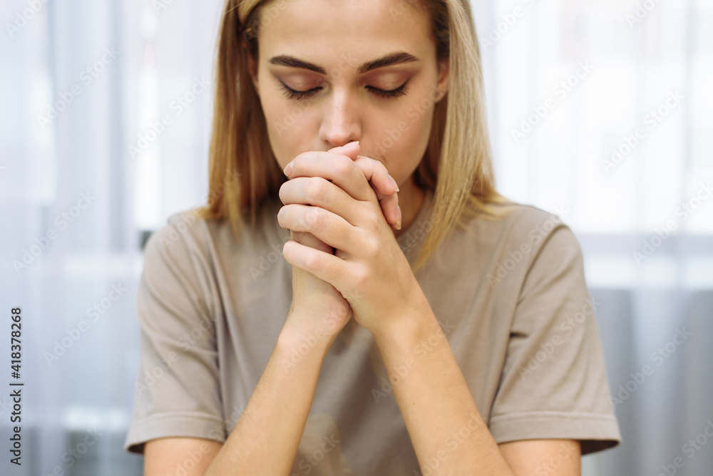 Cute beautiful young woman folded her hands in prayer. A woman asks God for help Cute beautiful young woman folded her hands in prayer. A woman asks God for help