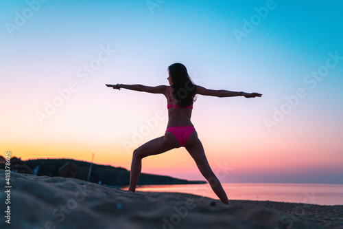 Beautiful woman on themedicine yoga asana balance energy on the beach