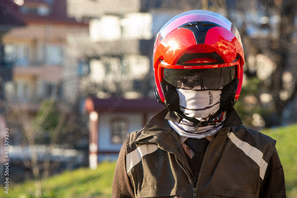 Armed man wearing a red motorcycle helmet. Armed man wearing a red motorcycle helmet.