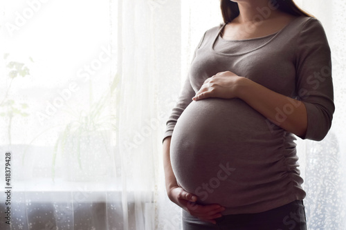 Photos Pregnant woman with big belly at window