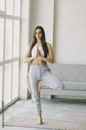 Girl in good physical shape. Yoga exercises. Girl with long hair