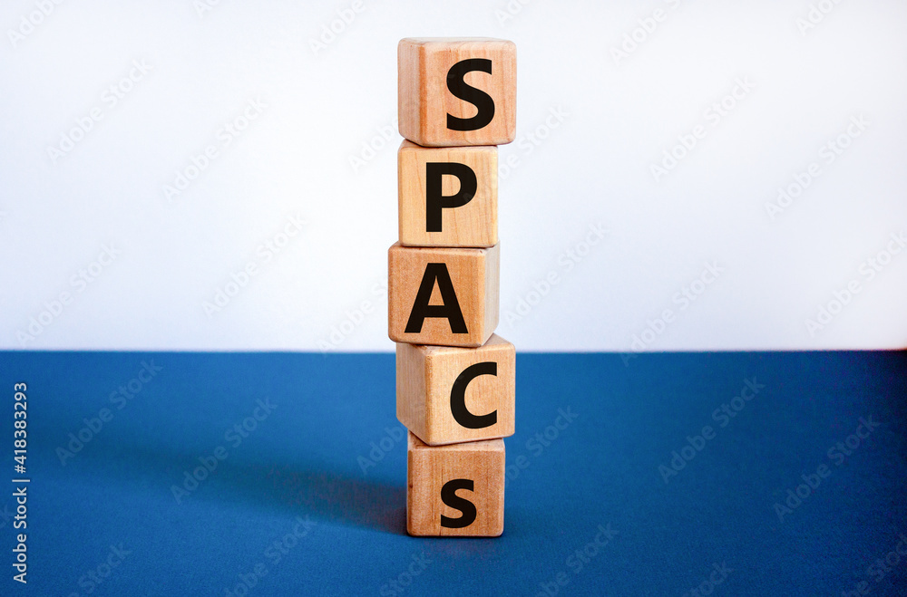 SPACs symbol. Wooden cubes with words 'SPACs, special purpose acquisition companies' on beautiful white and blue background, copy space. Business and SPACs concept. SPACs symbol. Wooden cubes with words 'SPACs, special purpose acquisition companies' on beautiful white and blue background, copy space. Business and SPACs concept.