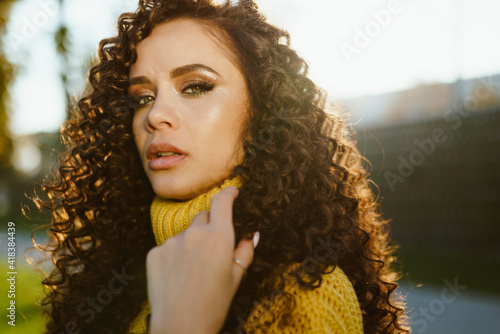 The curly brunette looked chiseled with chiseled facial features inquiringly looking into the camera. close-up. High quality photo photo