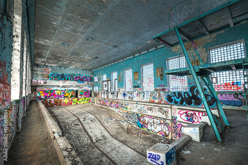 Obraz na płótnie Abandoned Soviet time swimming pool and sports hall complex. Colorful graffiti paintings on the walls. Urban exploration. w salonie