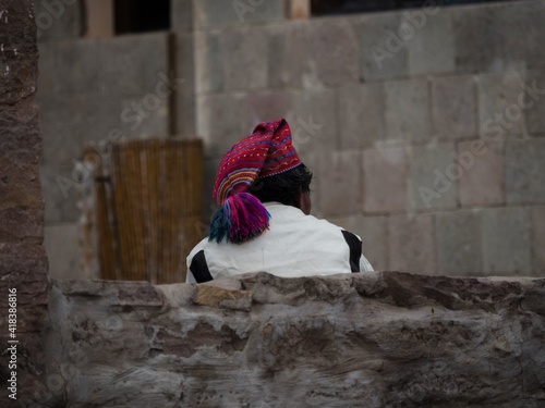 Indigenous man wearing traditional white costume colorful knit cap bobble hat on Taquile Island Titicaca Lake Puno Peru photo