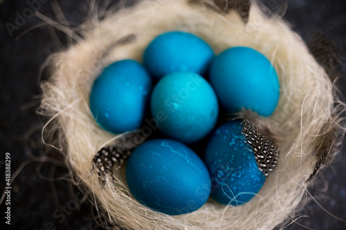 Blue Easter eggs with twigs in a decorative nest