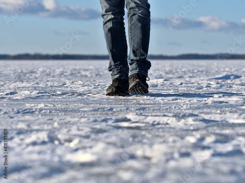 A person walking over lake ice, only legs visible.