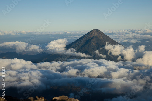 Aerial view of A Water volcano surrounded by clouds in Guatemala early in the morning seen from Acatenango Volcano