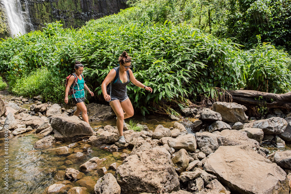 Hikers crossing stream, Waipipi Trail, Maui, Hawaii Hikers crossing stream, Waipipi Trail, Maui, Hawaii