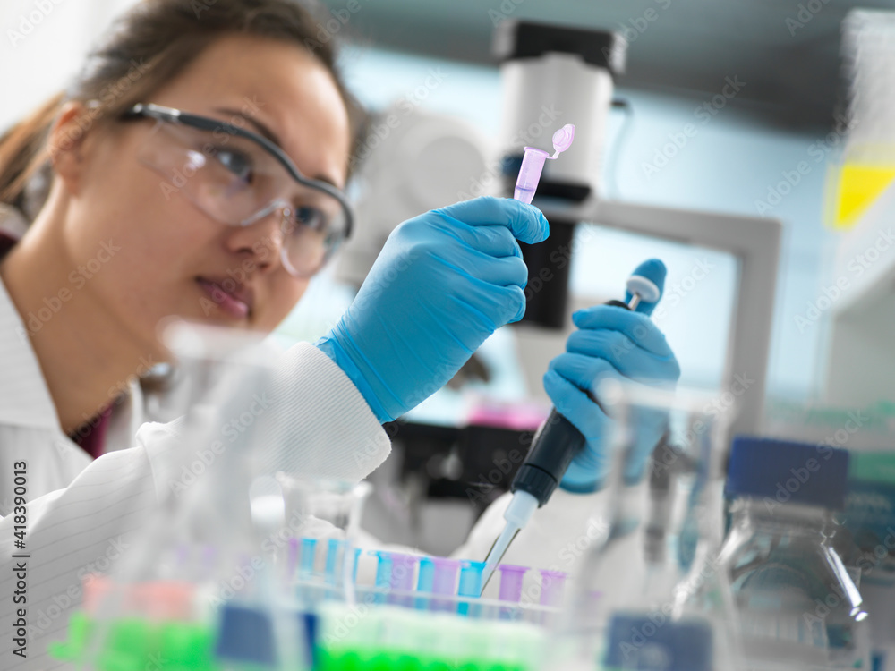 Scientist pipetting sample into vial for genetic testing in laboratory Scientist pipetting sample into vial for genetic testing in laboratory