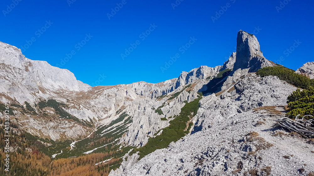 Panoramic view on mountains in Hochschwab region, Austrian Alps. The flora overgrowing slopes is turning golden. Autumn vibes in the mountains. Sharp and high peaks. Freedom and wilderness
