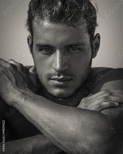 Sexy closeup portrait of handsome topless male model with beautiful eyes looking into camera. Black and White. 