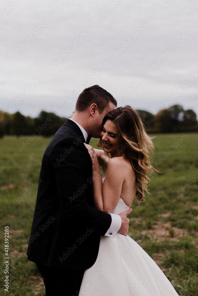 Romantic young bride and groom hugging in field Romantic young bride and groom hugging in field