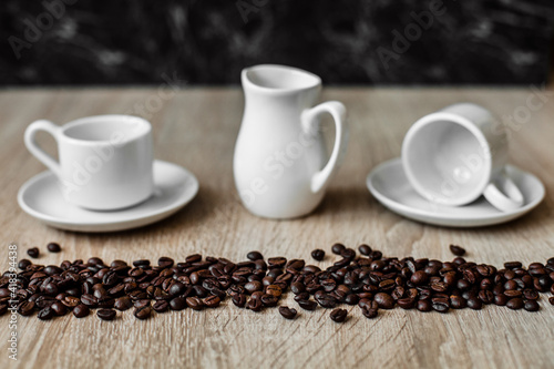white cups, coffee beans, dark background
