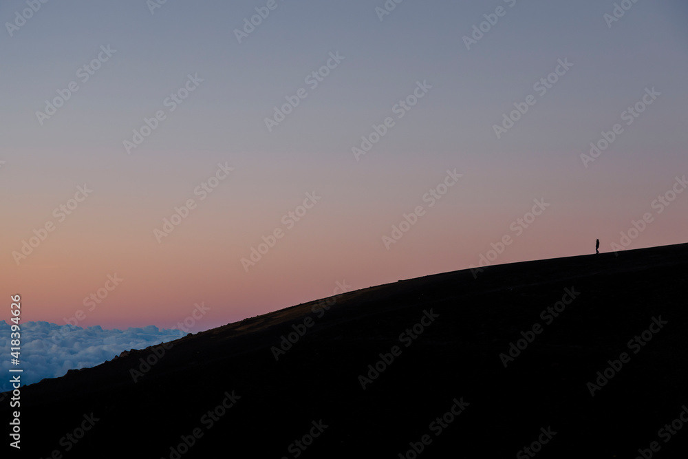 Sunset on the top of Acatenango volcano in Guatemala - one person alone on the big mountain with the colorful sky in the background- concept of loneliness - alone in the world Sunset on the top of Acatenango volcano in Guatemala - one person alone on the big mountain with the colorful sky in the background- concept of loneliness - alone in the world
